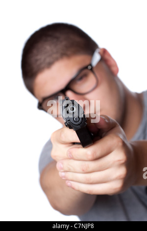 Eine böse aussehende Teenager mit Brille zeigt eine schwarze Pistole auf den Betrachter. Geringe Schärfentiefe. Stockfoto