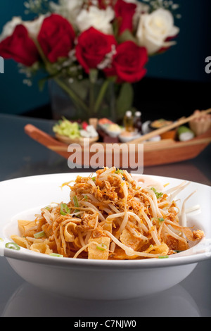 Ein thailändisches Gericht Crisy Nudeln und Sojasprossen in einer großen weißen Schüssel mit Stäbchen. Stockfoto