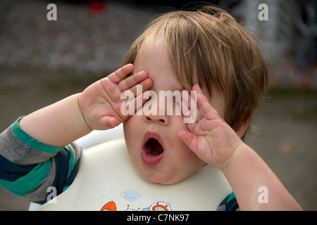 Sehr müde Kleinkind Gähnen außerhalb nach Essen Stockfoto