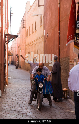 Kleinen marokkanischen jungen genießen eine Fahrt auf seines Vaters moped Stockfoto