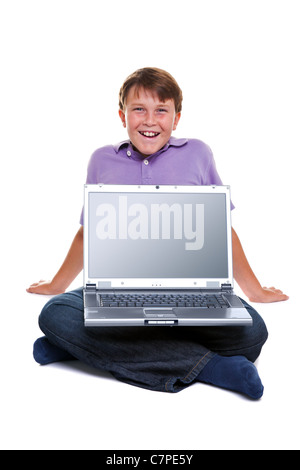 Ein 11 Jahre alter Junge mit einem Laptop-Computer, isoliert auf weiss mit Beschneidungspfad für den leeren Bildschirm. Stockfoto