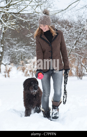 Frau zu Fuß Hund im Schnee Stockfoto