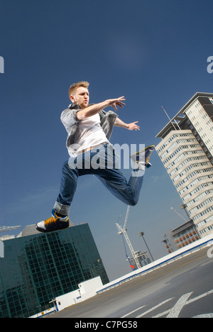 Mann springt auf städtischen Dach Stockfoto