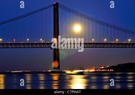 Portugal, Lissabon: Nächtlich beleuchteten Ponte 25 de Abril mit Vollmond Stockfoto