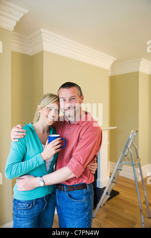 Lächelnde paar umarmt im neuen Zuhause Stockfoto