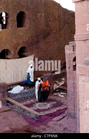 Orthodoxe christliche Priester beten in die Felsen gehauene Kirche von Bet Maryam in Lalibela, Nord-Äthiopien, Afrika. Stockfoto