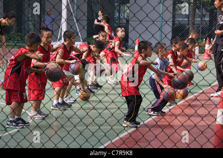 Kinder spielen Basketball in der Schule, Guangzhou, Guangdong, China Stockfoto