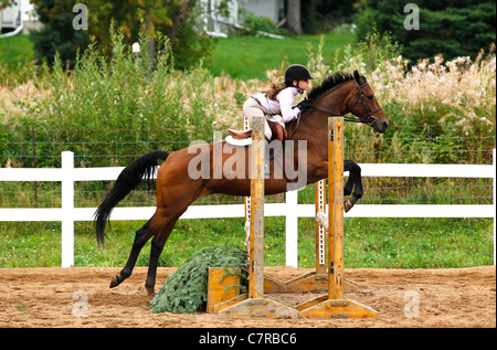 Junges Mädchen Reiter Springen einen Zaun Stockfoto