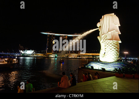 Marina Bay Sands hinter dem Merlion-Brunnen in der Nacht in Singapur Stockfoto