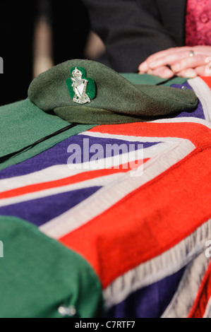 Der Green Beret der Royal Ulster Rifles und eine Fahne drapiert über den Sarg eines Soldaten Stockfoto