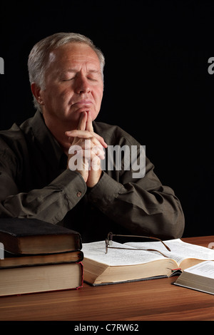 Senior Pastor meditieren und Führung im Gebet suchen Stockfoto