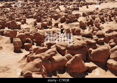 Ein junger Mann klettert man die Felsformationen im Goblin Valley State Park, Utah Stockfoto