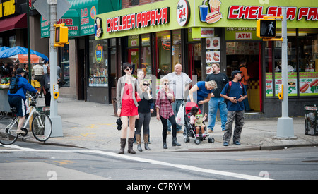 Fußgänger überqueren Sie die Kreuzung der Seventh Avenue und West 23rd Street im Stadtteil Chelsea in New York Stockfoto