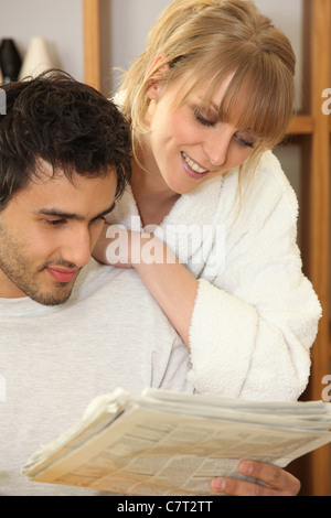 Junges Paar betrachten eine Morgenzeitung Stockfoto