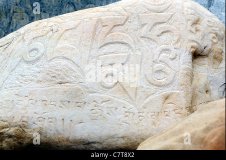 Ein Fluss-Stein geschnitzt mit dem Mantra Om Mani Padme Hum auf ein Gebet-Wand.  Sumar, Nubra Valley, Ladakh, Republik Indien. Stockfoto