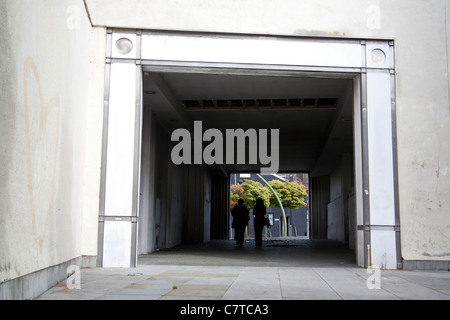 Zwei Personen zu Fuß durch einen Fußgängertunnel mit Bäumen eingerahmt an der Ausfahrt, Liverpool England UK Stockfoto
