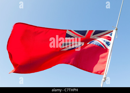 Die Red Ensign, bekannt als der rote Duster, fliegen im Wind vor blauem Himmel Stockfoto