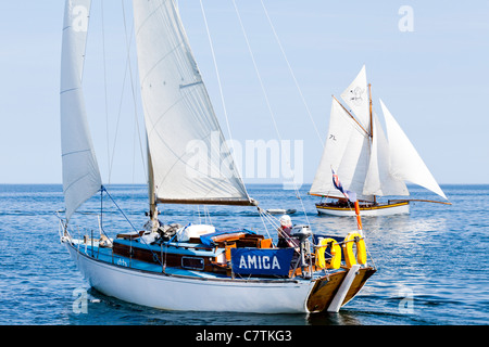 Die Yacht 'Amica' passiert ein Falmouth-Austernboot in den ruhigen Gewässern von Falmouth Bay, Cornwall UK Stockfoto