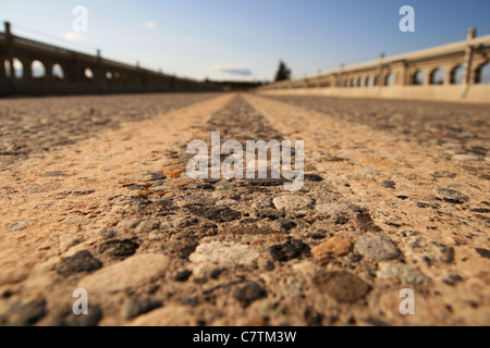 Blick vom sehr nah an das Pflaster in der Mitte der Fahrbahn auf einer Brücke mit sehr geringen Schärfentiefe Stockfoto