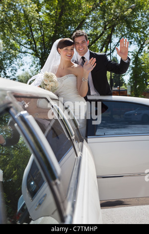 Braut und Bräutigam stehen in Limo winken Stockfoto