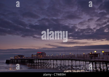 Worthing Pier, West Sussex, nachts, mit bewölktem Himmel Stockfoto