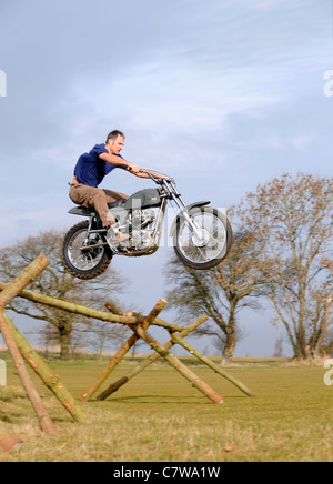 Motorrad-Studien-Fahrer Steve Colley im Carswell Golf Club, Oxfordshire Neuerstellung McQueens berühmten Sprung von der großen Es Stockfoto