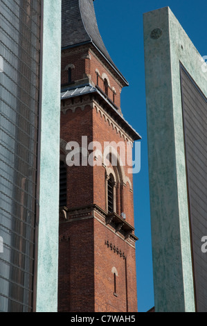 Die Glocke Turm von St. Peter-church,Ancoats,Manchester.Viewed zwischen zwei der fünf Wächter des Künstlers Dan Dubowitz Stockfoto