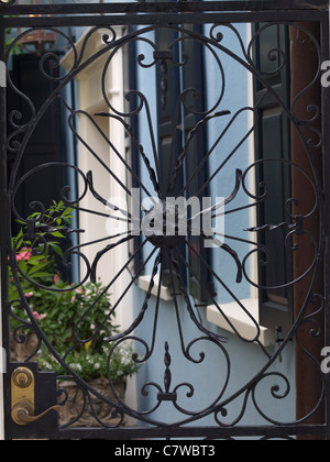 Eisernes Tor vor bunten georgischen Reihenhaus auf Rainbow Row in Charleston, South Carolina. Stockfoto