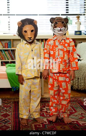 Zwei Kinder mit Masken auf im Pyjama Stockfoto