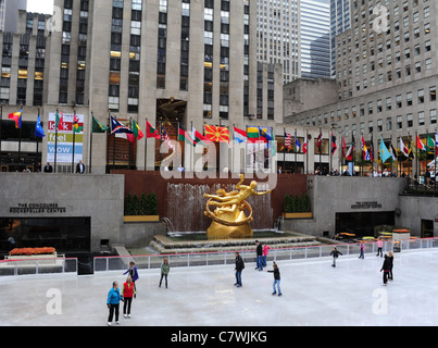 Ansicht der Eisläufer, versunkene Hof Front vergoldeten Prometheus Skulptur und GE Building, Rockefeller Center Ice Rink, New York Stockfoto