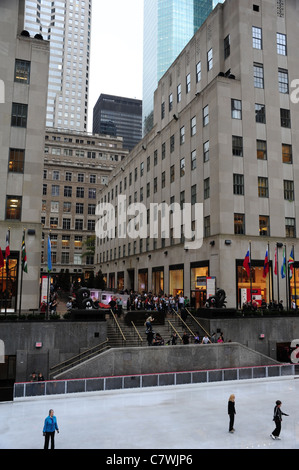 Porträt-Eisläufer, in Richtung Kanal Promenade Treppen und Wolkenkratzer, Rockefeller Center Ice Rink, New York City Stockfoto