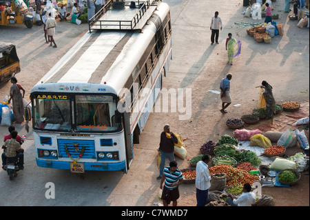 Blick hinunter auf einen indischen Bus Fahrt durch ein Straßenmarkt in Puttaparthi. Andhra Pradesh, Indien Stockfoto