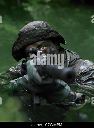 Spezielle Operationen Kräfte Soldat Transite das Wasser mit einem Sturmgewehr bewaffnet. Stockfoto