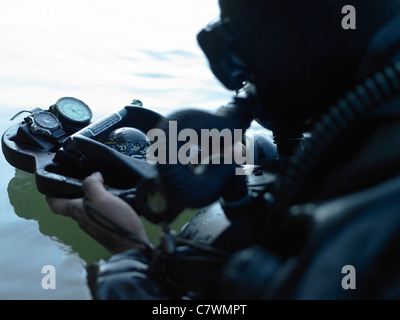 Special Forces combat Diver wirft einen Blick auf seinen Kompass, um sicherzustellen, dass er auf dem Weg zum Ziel befindet. Stockfoto