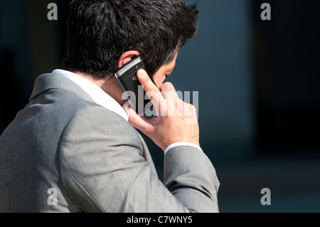 männlicher Büroangestellter mit Handy Stockfoto