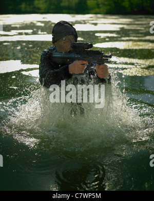 Special Operations Forces Soldaten ergibt sich aus dem Wasser mit einem Sturmgewehr Steyr AUG bewaffnet. Stockfoto