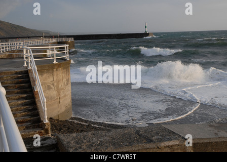 Wellen, die gegen die Kaimauer in Aberystwyth, Wales Stockfoto