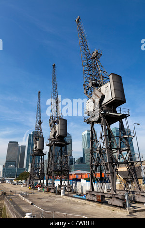 West India Docks mit den alten Kranen und Canary Wharf in den Hintergrund, Docklands, London, England, UK. Stockfoto