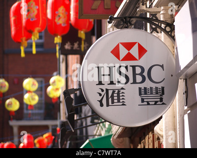 Zweisprachige Zeichen in Englisch und Chinesisch hängen außerhalb der HSBC-Bank-Filiale in Londons Chinatown Stockfoto