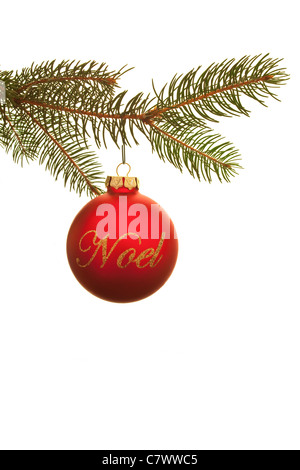 Christbaumkugel mit dem Noel geschrieben steht in Kursivschrift von einem Tannenzweig hängen Stockfoto