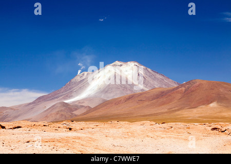 Die atemberaubende Landschaft zwischen San Pedro de Quemez und Ojo de Perdiz, Bolivien, mit Dampf steigt aus dem Vulkan in eine dünne Rauchfahne Stockfoto