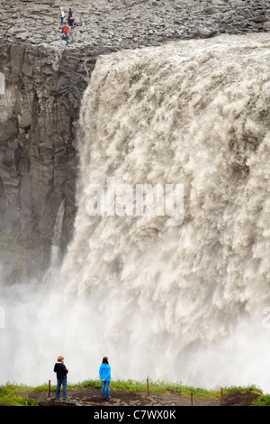 Touristen am Dettifoss-Wasserfall am Fluss Jökulsá Á Fjöllum in der Nähe von Myvatn im Vatnajökull-Nationalpark, Nordosten Islands. Stockfoto