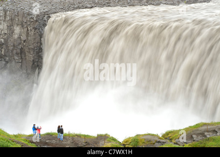 Touristen am Dettifoss-Wasserfall am Fluss Jökulsá Á Fjöllum in der Nähe von Myvatn im Vatnajökull-Nationalpark im Nordosten Islands. Stockfoto