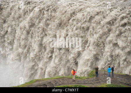 Touristen am Dettifoss-Wasserfall am Fluss Jökulsá Á Fjöllum in der Nähe von Myvatn im Vatnajökull-Nationalpark im Nordosten Islands. Stockfoto