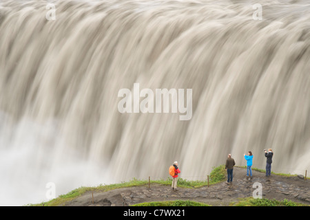 Touristen am Dettifoss-Wasserfall am Fluss Jökulsá Á Fjöllum in der Nähe von Myvatn im Vatnajökull-Nationalpark im Nordosten Islands. Stockfoto