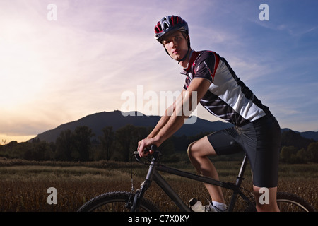 sportlichen Aktivität: jungen Erwachsenen Radfahrer fahren Mountainbike in der Natur. Horizontale Form, Seitenansicht, Textfreiraum Stockfoto