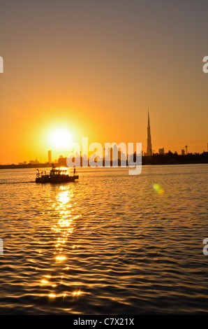 ein Mann im Boot in der Nähe Burj Khalifa Dubai bei Sonnenuntergang Stockfoto