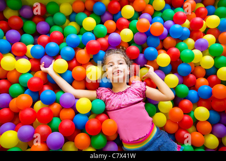 Kind Mädchen spielen auf bunten Kugeln Spielplatz hohe Sicht Stockfoto