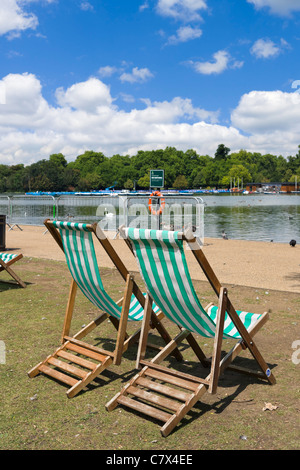 Liegestühle mit der Serpentine in Hyde Park, London, England, UK Stockfoto