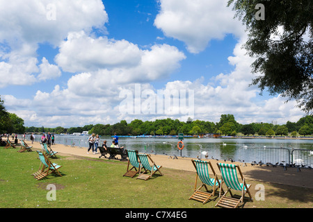 Liegestühle mit der Serpentine in Hyde Park, London, England, UK Stockfoto